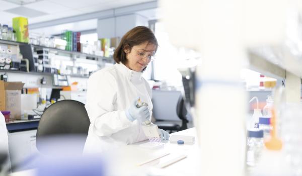 A female ovarian cancer researcher smiling while working in a lab