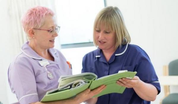 Two nurses discussing patient notes in a chemotherapy unit