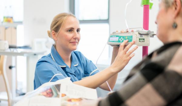 A nurse looking at a woman with ovarian cancer during treatment