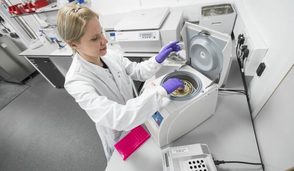 A female ovarian cancer researcher using equipment in a lab