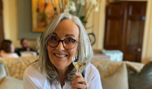 Helen wearing glasses and holding a glass of wine