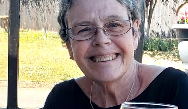 A photo of Helen sat at a restaurant smiling