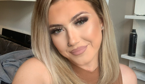 A selfie of summer in a brown top smiling to the camera