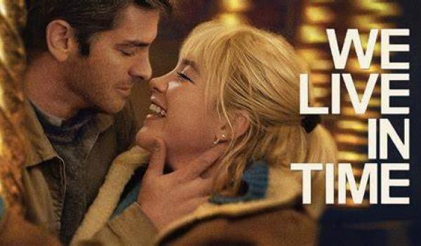 The poster for the film We Live in Time - it features a man and woman looking at each other closely and smiling