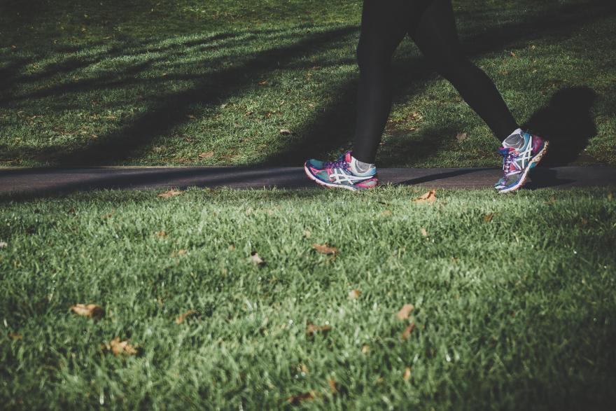 A person wearing sports gear walking on grass
