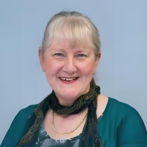 Headshot of Jenny wearing a green top and a black scarf