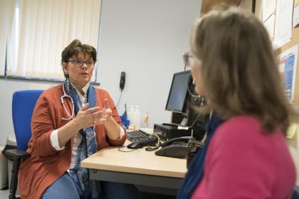 A GP using hand gestures whilst talking to a woman with ovarian cancer