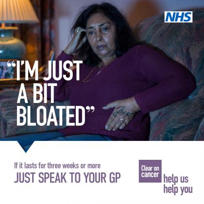 NHS campaign poster which reads ‘I’m just a bit bloated’ on an image of a woman sitting on her sofa looking concerned