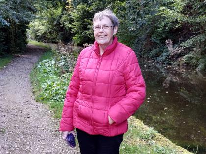 Helen out on a walk wearing a red coat and similing