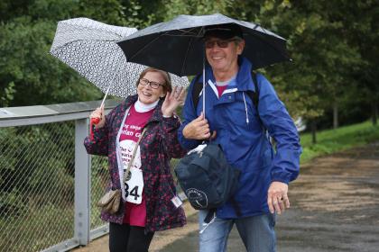 Pauline and her husband at the Ovarian Cancer Walk Run, smiling and waving at the camera (1).jpg