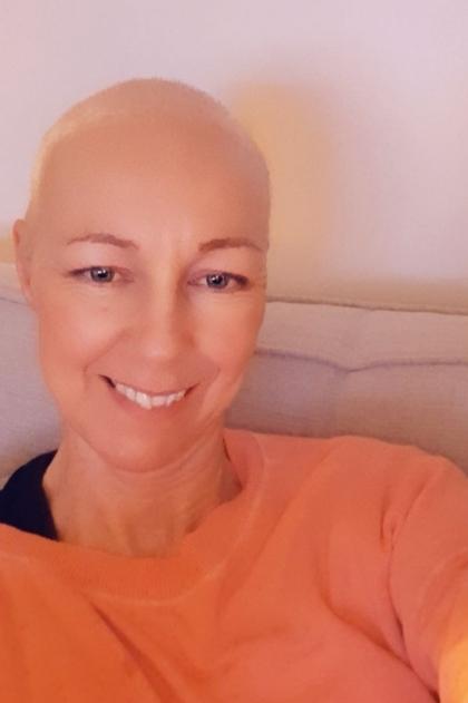 A selfie of Karen after treatment wearing an orange tshirt