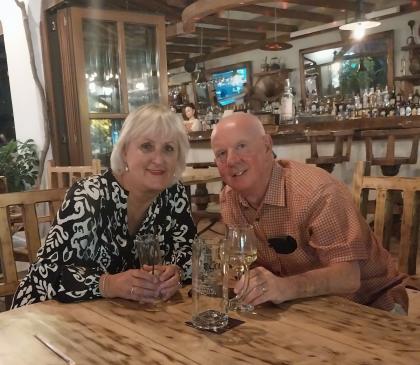 Sue and her husband having a drink in a bar, both smiling and happy