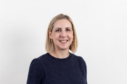 A headshot image of Helen smiling towards the camera wearing a black top