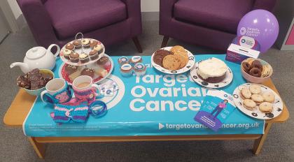 A photo of cakes, tea and Target Ovarian Cancer branded materials displayed on a table