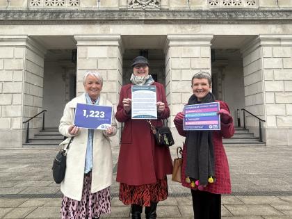 Three Target Ovarian Cancer Campaigners at Stormont holding awareness raising posters