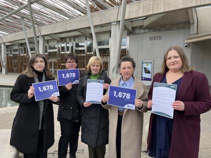 The Target Ovarian Cancer team and two campaigners standing outside of Scottish Parliament before handing in their petition 