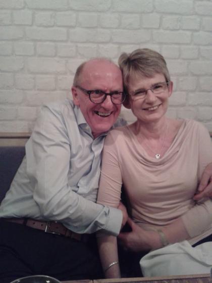 A photo of Stephen and Julie with their arms round each other smiling together