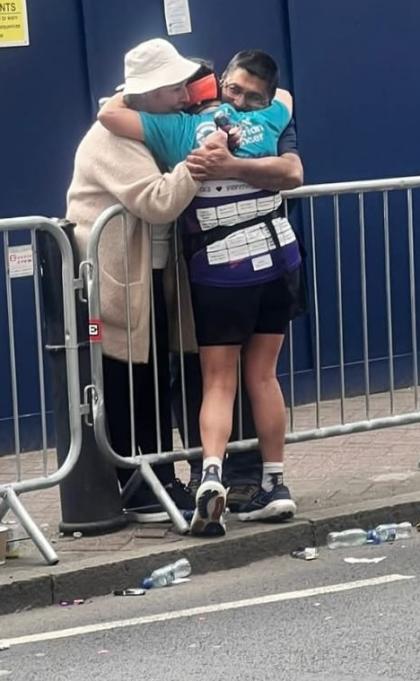 A photo of Donna running the London Marathon hugging her friend Debbie as she is watching on the sideline