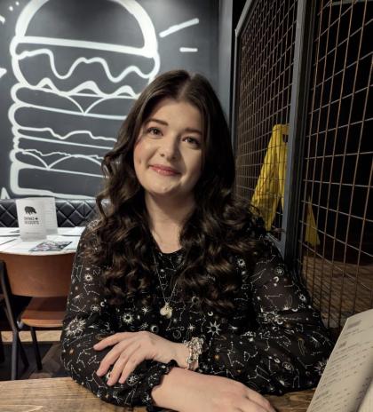 Heleena sitting in a restaurant smiling at the camera