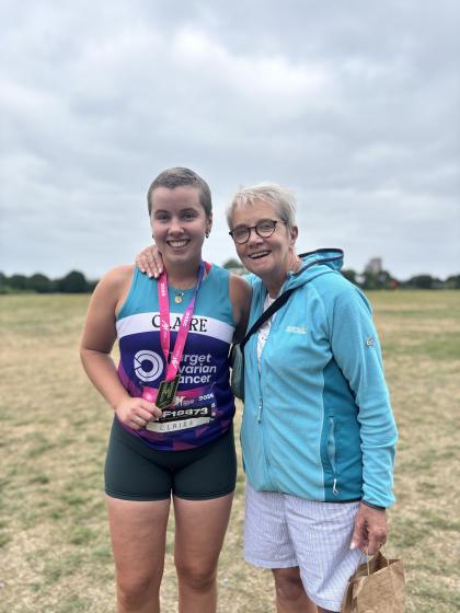 Claire after running the Hackney Half Marathon wearing a medal and a Target Ovarian Cancer running vest