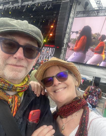 Nicola and her husband Graeme standing in a crowd at a concert infront of the stage both smiling