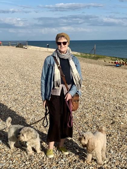 Nicola standing on the beach with her two small dogs