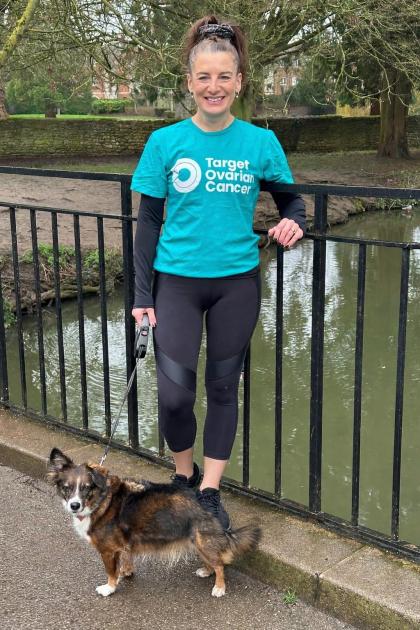 Lisa standing by a river wearing a teal coloured Target Ovarian Cancer tshirt